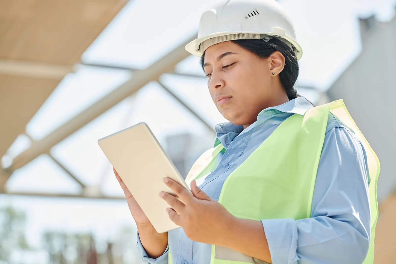 Une responsable des opérations consulte une tablette sur un site industriel.